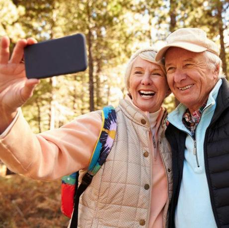 Coppia senior in escursione in una foresta prendendo un selfie