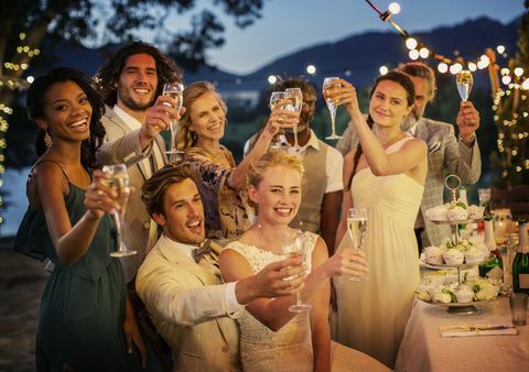 Ospiti di nozze brindando con champagne durante il ricevimento di nozze in giardino