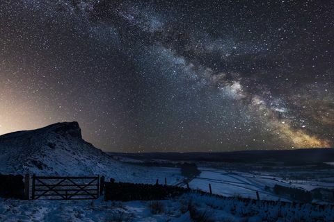 Immagine composita vibrante della Via Lattea sopra paesaggio del parco nazionale di punta innevato del distretto in Inghilterra