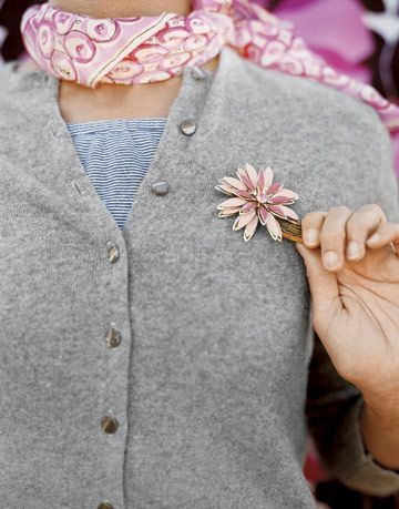 Maglione grigio con spilla a fiore rosa