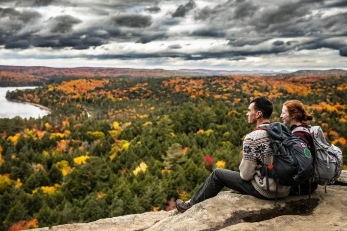 giovane coppia rilassante guardando la vista del lago e del fogliame autunnale in montagna