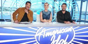 lionel richie, katy perry e luke bryan seduti a una scrivania con il logo american idol davanti