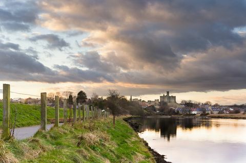 cielo suggestivo che riflette il castello di Warkworth nel fiume coquet