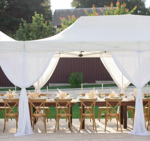 tavolo festivo sotto il baldacchino bianco vicino alla piscina