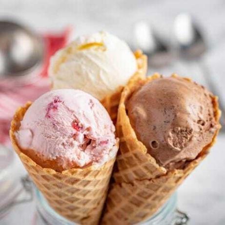 gelato alla fragola, vaniglia, cioccolato con cono di cialda su fondi di pietra di marmo