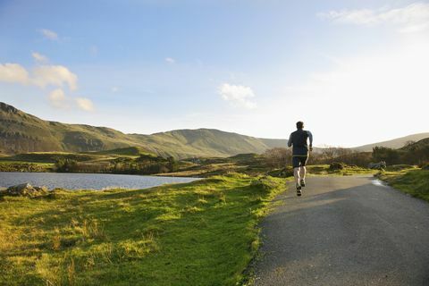 uomo che corre su strada rurale