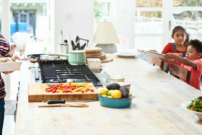 donna che tiene una casseruola calda in cucina