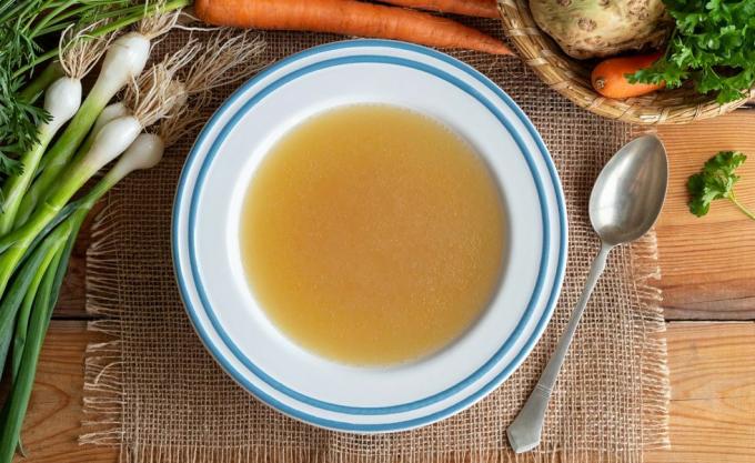 Brodo di ossa di pollo in un piatto con verdure