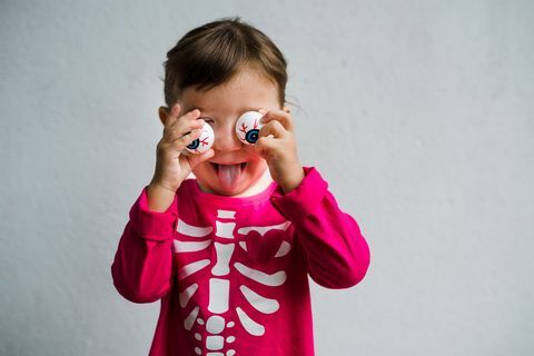 bambina vestita in una camicia scheletro con occhiali divertenti