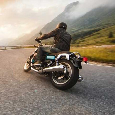 motociclista a cavallo nel passo dolomitico, italia, europa