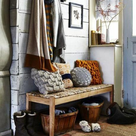 Corridoio decorato con cuscini intrecciati e coperte di lana