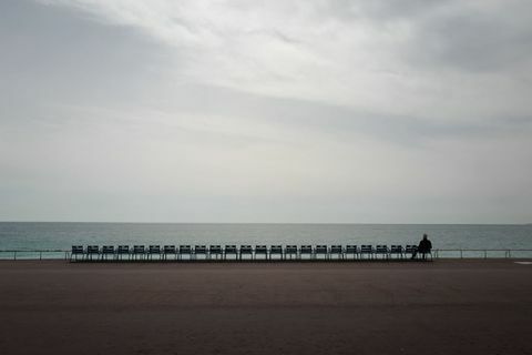 topshot un uomo guarda il mare mediterraneo sulla promenade des anglais nella città di Nizza, riviera francese, dopo un severo blocco che ha richiesto alla maggior parte delle persone di entrare la francia di rimanere a casa è entrata in vigore il 17 marzo 2020 un rigoroso blocco che richiede alla maggior parte delle persone in francia di rimanere a casa è entrato in vigore a mezzogiorno 17 marzo 2020, vietando tutte le uscite tranne quelle essenziali nel tentativo di frenare la diffusione del coronavirus foto di valery hache afp foto di valery hacheafp via getty immagini