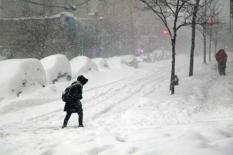 Via dell'incrocio della donna durante la bufera di neve Jonas nel Bronx