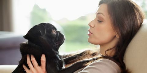 Donna che si distende con il cane sul sofà